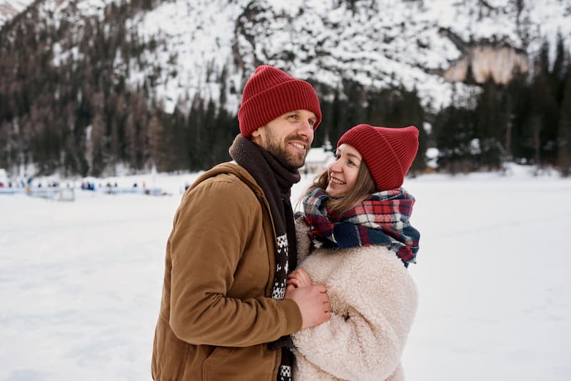 Couple dressed for winter standing close together on a cold snowy day